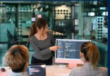 Woman presenting information off a computer screen to a man and a woman