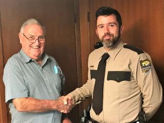 Board Chairman John "Skip" O'Donnell shaking Park Ranger Erik Johnson's hand.