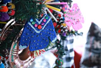 Miniature sweaters hanging on a Christmas tree.