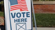 Sign reading "Vote Here".