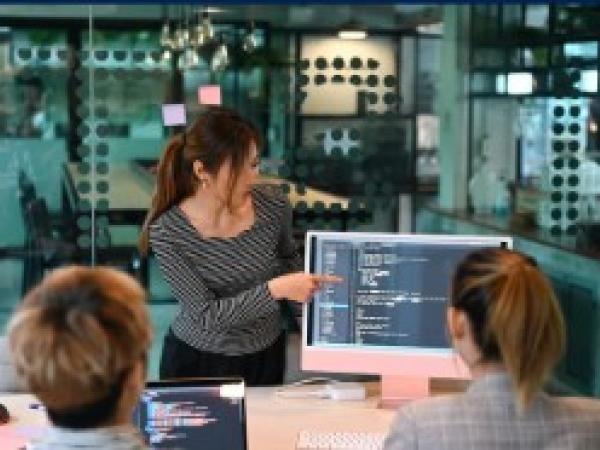 Woman presenting information off a computer screen to a man and a woman